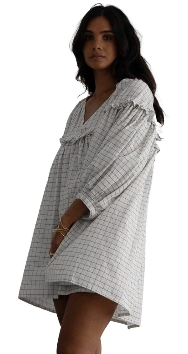 White Checkered Babydoll Dress V-Neck 9 White Checkered Babydoll Dress V-Neck Model wearing white checkered babydoll dress with V neck puff sleeves and relaxed mini silhouette