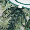 Close-up of women's corset top with green floral pattern and lace-up design for stylish outfits